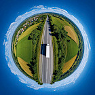 Lkw auf einer Landstra&szlig;e als kugelf&ouml;rmiges Tiny-Planet-Panorama
