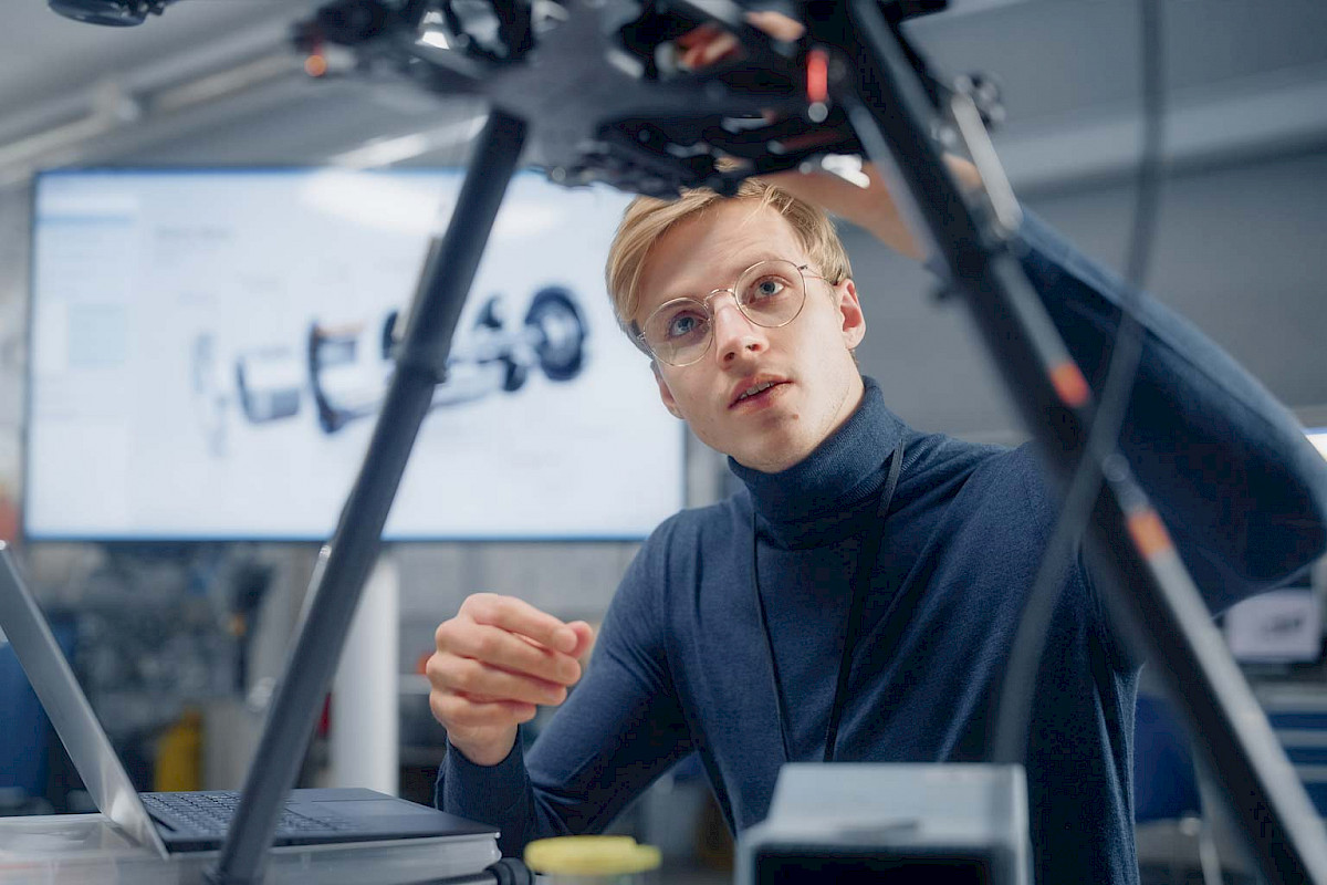 Junger Ingenieur untersucht eine Drohne in einem Entwicklungslabor